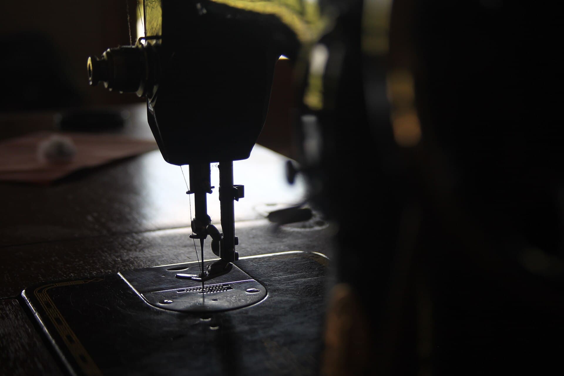 An industrial sewing machine, needle down on the plate